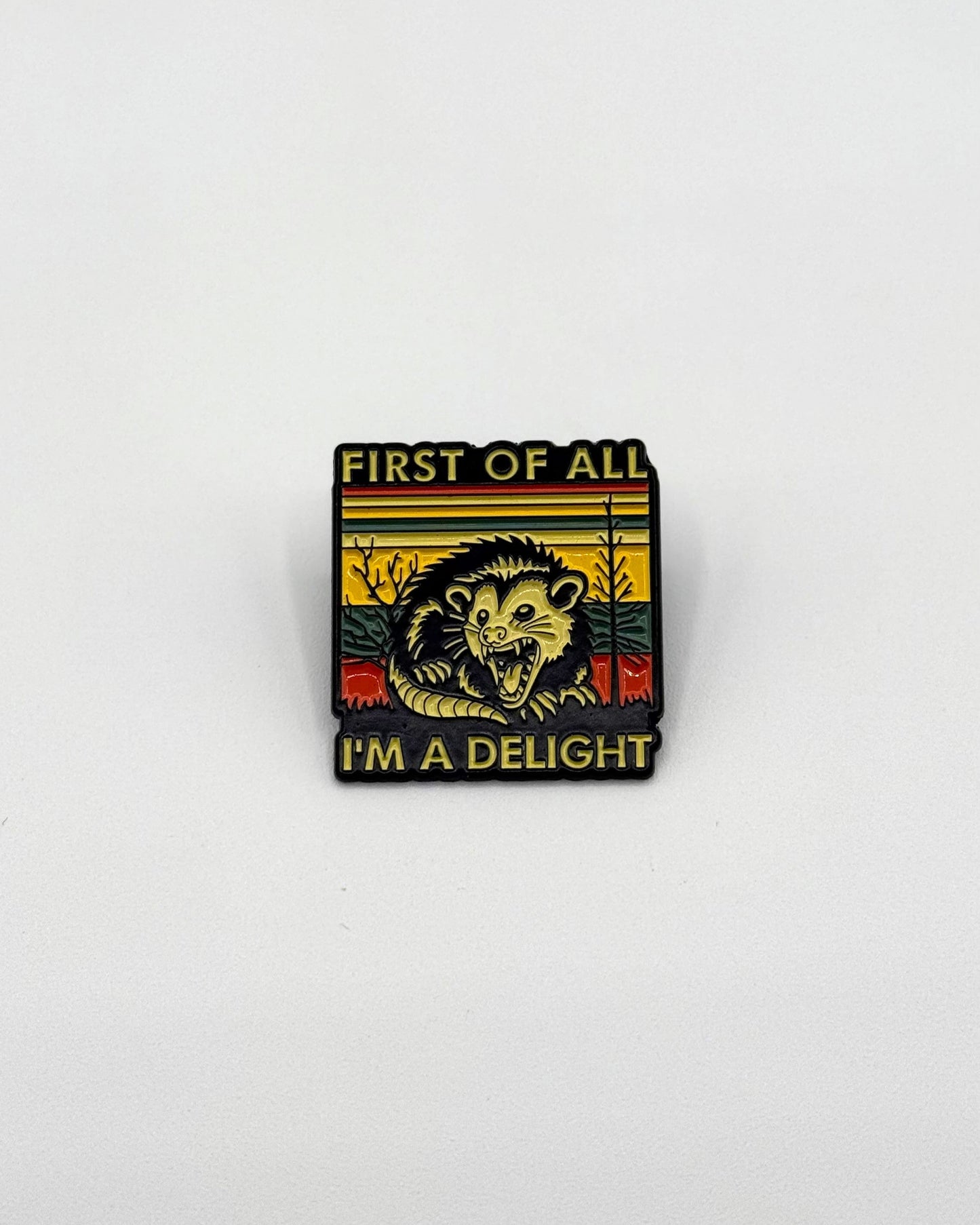 Enamel pin with a picture of a screaming opossum with text first of all i'm a delight